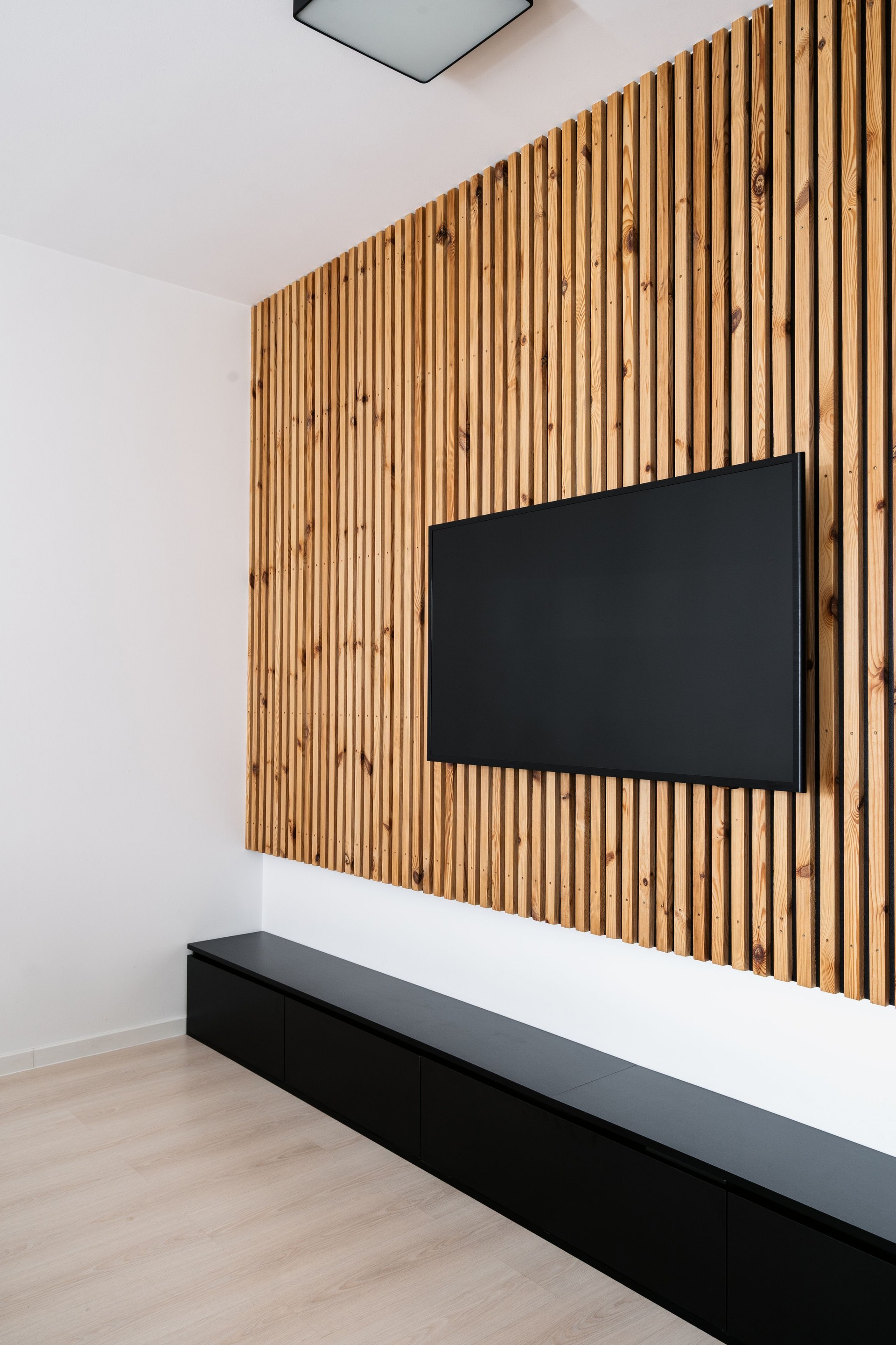 Télévision à écran plat moderne montée dans un élégant salon en panneaux de bois